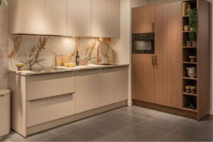 Moderne recht keuken beige met warm marmerlook werkblad en noten houtlook kastenwand met oven