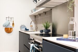 Blauwe keuken greeploos met inductie fornuis en spoelkraan