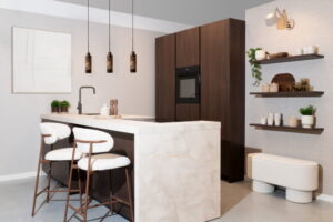 Modern schiereiland met bar – notenhout eiland en hoge kasten met doorlopend beige marmerlook werkblad