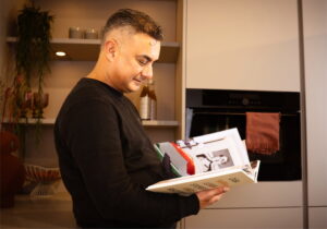 Keukencoach Murat kijkt in een Italiaans kookboek