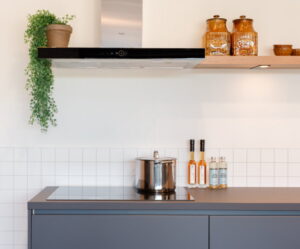 Grote soeppan vol met stoofpeertjes op inductiekookplaat met Whirlpool afzuigkap erboven Grote soeppan vol met stoofpeertjes op inductiekookplaat met Whirlpool afzuigkap erboven
