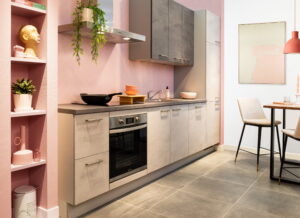 Betonlook keuken met pastel roze tegelachterwand