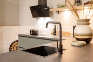 Groene Mid Century Modern keuken vintage look met zwarte keukenkraan en spoelbak, inductiekookplaat en wand afzuigkap Groene Mid Century Modern keuken vintage look met zwarte keukenkraan en spoelbak, inductiekookplaat en wand afzuigkap