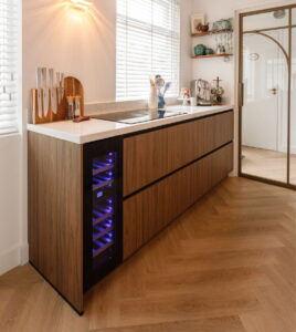 Eiken visgraat PVC vloer in een notenhouten keuken met wijnklimaatkast - Binnenkijker bij trotse I-KOOK klant, Tilburg Eiken visgraat PVC vloer in een notenhouten keuken met wijnklimaatkast - Binnenkijker bij trotse I-KOOK klant, Tilburg