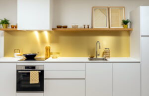 Greeploze witte keuken met wit blad en goudkleurige achterwand Greeploze witte keuken met wit blad en goudkleurige achterwand