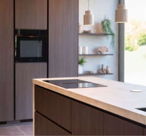 Donkerhouten keuken - hoge kastenwand, kookeiland en wandpanelen met marmerlook werkblad Donkerhouten keuken - hoge kastenwand, kookeiland en wandpanelen met marmerlook werkblad