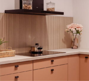 Zwarte inductiekookplaat & afzuigkap in moderne keuken koraal kleur Zwarte inductiekookplaat & afzuigkap in moderne keuken koraal kleur