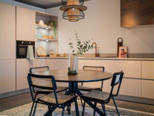Rieten hanglamp boven retro webbing eetkamerstoelen - zwarte stoelen met rugleuning en zitvlak van gevlochten riet Rieten hanglamp boven retro webbing eetkamerstoelen - zwarte stoelen met rugleuning en zitvlak van gevlochten riet