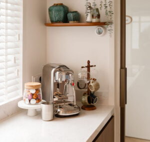 Noten houten keuken met een gezellige koffiehoek en een chroom espressoapparaat Noten houten keuken met een gezellige koffiehoek en een chroom espressoapparaat